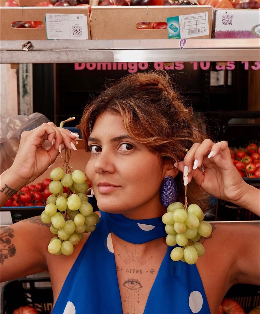 Retrato de Thayna Auni com dois cachos de uvas junto às orelhas